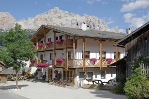 Un grand bâtiment blanc avec des fleurs sur les balcons dans l'établissement Residence Sas Vanna, à La Villa