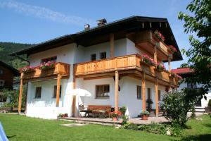 a large white house with a wooden balcony at Haus Bergblick in Reit im Winkl
