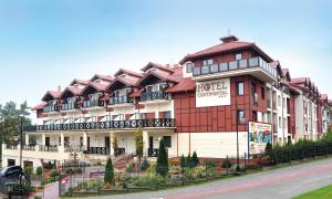 a hotel with a red and white building at Hotel Continental in Krynica Morska