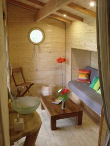 Habitación con cama y lavamanos en una cabaña en La Cabane du Vieux Chêne, en Susmiou