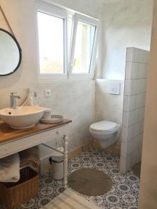 a bathroom with a sink and a toilet at L'Ermitage in Saint-Vaast-la-Hougue