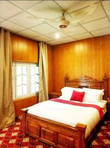 a bedroom with a large bed with red pillows at The Metropolitan Hotel Gahkuch in Dargai