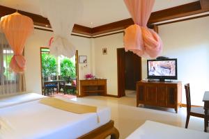 una camera da letto con un letto e una TV a schermo piatto di Oriental Siam Resort - SHA Extra Plus Certified a Chiang Mai