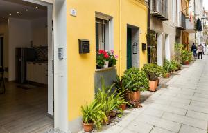 カリアリにあるLovely Apartment Via Piccioniの通り鉢植えの黄色い建物