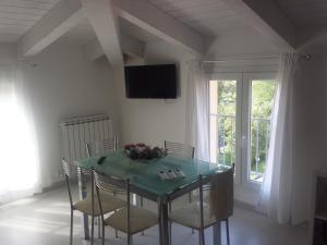 ein Esszimmer mit einem Tisch mit Stühlen und einem TV in der Unterkunft Apartments Arcobaleno in Deiva Marina