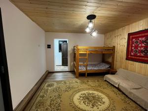 a bedroom with a bunk bed and a rug at Ethno Guest House Caravan Tamchy in Tamchy