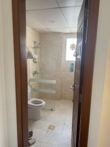 Un baño con inodoro y ducha de cristal. en 2 Bedroom Apartment, en Mascate