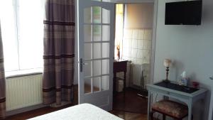 ein Schlafzimmer mit einer Tür, die zu einem Zimmer mit einem Bett führt in der Unterkunft Maison d'hôtes La Tuilerie in Peschadoires
