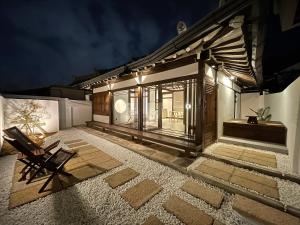 a house with a chair on a patio at night at Hanok Stay - Ladam in Jeonju