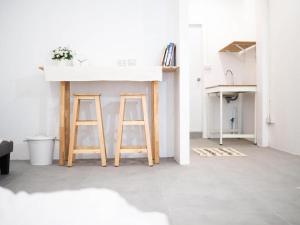 a kitchen with a counter and two wooden stools at Unyak Room Ayutthaya in Phra Nakhon Si Ayutthaya