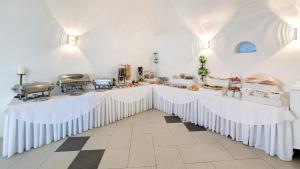 a white room with two tables with food on them at Dream Island Hotel in Fira