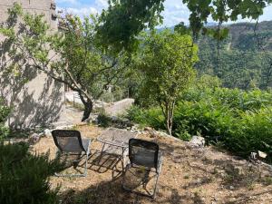 two chairs sitting next to a table in a yard at Casa Con Vista Panoramica a Cerreto di Cagli - Animali Ammessi in Pianello