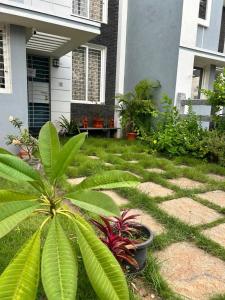 a yard with plants and a house at Beachside Bliss - Villa 32 in Kilpettai