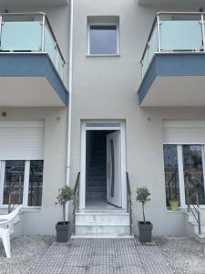 ネア・ペラモスにあるOpenSea2の階段と青い扉のある白い家
