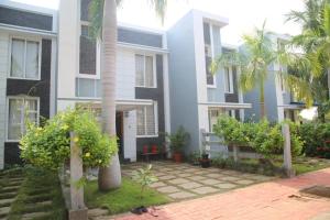 a house with palm trees in front of it at Beachside Bliss - Villa 32 in Kilpettai
