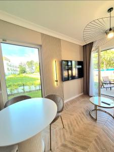 a living room with a white table and chairs at Let's Sea SPA - Premium Apartamenty z ogródkiem, przyjazne zwierzętom in Gąski