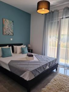 ネア・ペラモスにあるOpenSea2の青い壁の大きなベッドのある寝室
