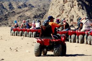 a group of people riding on atvs in the desert at Neptune Hotel in Dahab