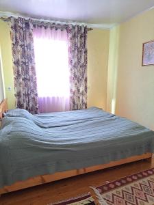 a large bed in a bedroom with a window at Ысык-Кол Чок-Тал in Chok-Tal