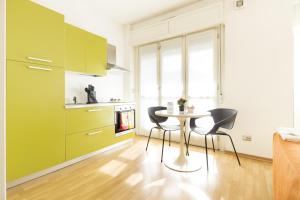 a kitchen with green cabinets and a table and chairs at Hotel Sharing in Turin