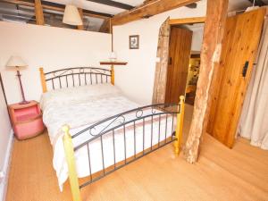 una camera da letto con un letto in una stanza di Rye Court Cottage a Birtsmorton