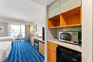 a hotel room with a bed and a microwave at Ala Moana Hotel Sleeps 4 near beach in Honolulu