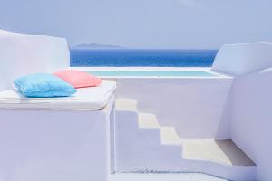 a white bed sitting next to a blue wall at Blue Waves Suites & Apartments in Kamari
