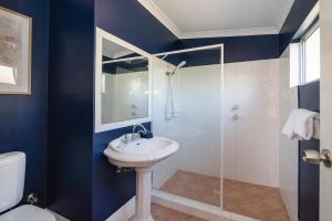 a blue bathroom with a sink and a shower at Seashells Beach house on Dorset in Busselton +8 photos