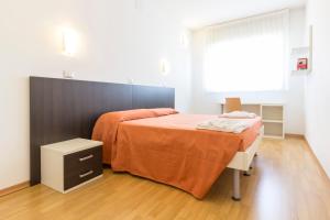 a bedroom with a bed with an orange blanket at Hotel Sharing in Turin