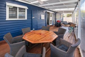 a patio with a wooden table and chairs at Seashells Beach house on Dorset in Busselton