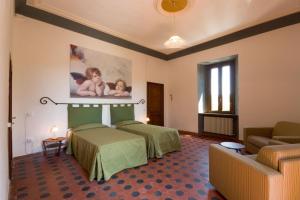 pokój hotelowy z dwoma łóżkami i kanapą w obiekcie Raffaello Residence w mieście Sassoferrato