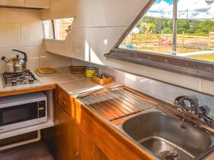 a kitchen with a sink and a microwave at The Rose in Rhondda