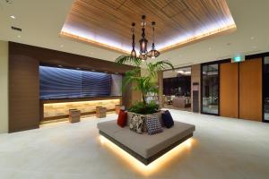 a lobby with a couch in the middle of a building at Almont Hotel Naha Kenchomae in Naha +87 photos