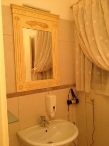 W łazience znajduje się umywalka i lustro. w obiekcie Le dimore Al Vecchio Teatro w mieście Ortona