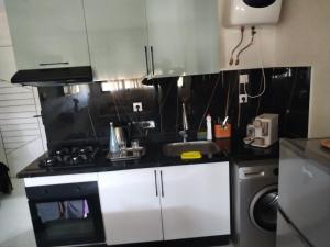 a kitchen with a sink and a stove top oven at Appartement à deux pas de l'océan - chez Nadia in Kenitra