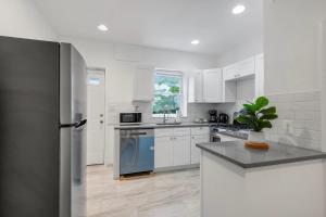 cocina con armarios blancos y nevera azul en Luxury 3br Townhome - Northern Liberty, en Filadelfia