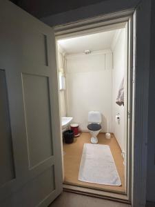 eine offene Tür zu einem Bad mit WC in der Unterkunft Tunnelmallinen Karsikon kansakoulu - jaettu kylpyhuone in Joensuu