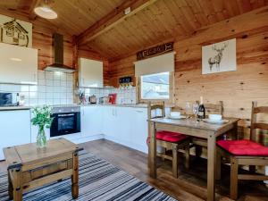 a kitchen and dining room with a table and chairs at Buttercup Lodge in Broomhill