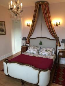 a bedroom with a white bed with a canopy at La Minaudière 62 in Boulogne-sur-Mer