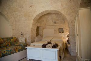 una camera con un letto e un muro in pietra di Annalocos a Locorotondo