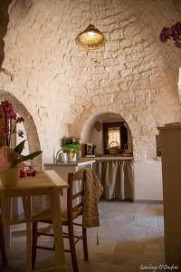 a kitchen with a table and a stone wall at Annalocos in Locorotondo