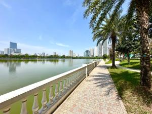 un trottoir à côté d'un plan d'eau avec des bâtiments dans l'établissement Luxury Two Bedroom, Fast Airport Access, Close to Marriott Hotel, à Hanoï