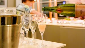 a person pouring a bottle of champagne into wine glasses at Hotel Binzer Hof in Binz
