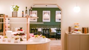 a dining room with a table with bowls of food at Hotel Binzer Hof in Binz