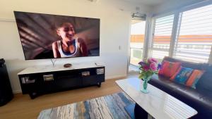 a living room with a large flat screen tv at Waves On Main 20 in Yamba