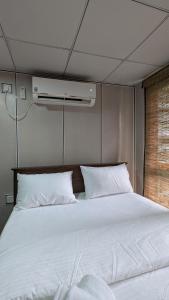 Una cama con sábanas blancas y almohadas en una habitación. en Harmony Hideaway Villa-Seeduwa, en Seeduwa