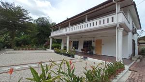 a large white building with a lot of plants at Santika in Kampong Jawa