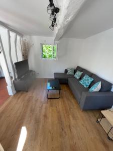 a living room with a couch and a table at Maison à la campagne in Auvilliers