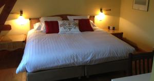 a bedroom with a large white bed with two lamps at Onsemhoeve in Dilbeek