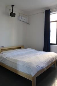 Una cama o camas en una habitación de Sanya Luyu B&B